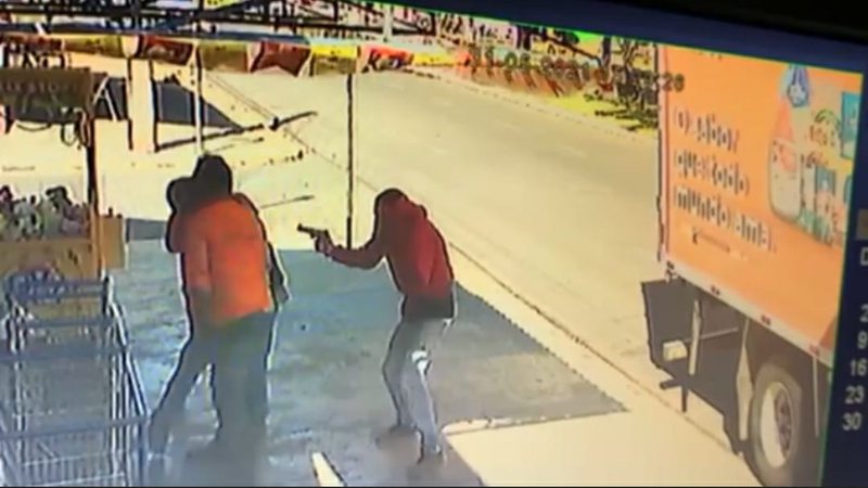 VÍDEO: imagens mostram dupla armada tentando assaltar caminhão em frente a mercado